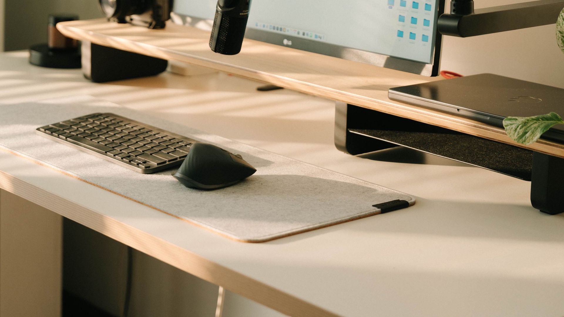 Bureau baigné de lumière naturelle avec souris ergonomique sur tapis en feutre